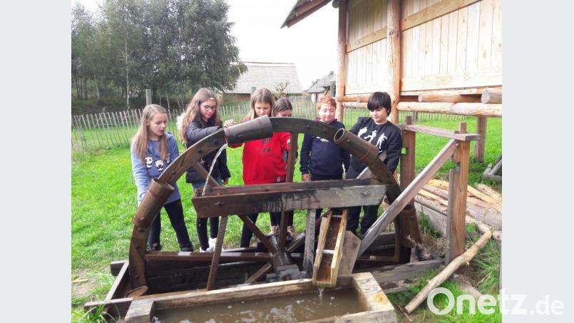 Die Kinder beim Wasserschöpfen am Wasserrad. Bild: adj