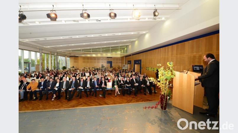 BRK-Bezirksgeschäftsführer Mario Drexler (am Rednerpult) begrüßt in der Neustädter Stadthalle die Festgäste beim Festakt zum 50jährigen Jubiläum der BRK-Berufsfachschule für Altenpflege und Altenpflegehilfe. Bild: bey