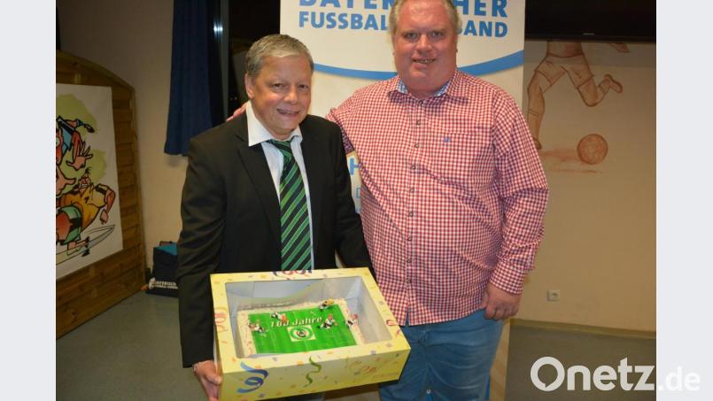 Mit einer Fußball-Torte gratulierte Ligakonkurrent Kickers Selb dem SV Mitterteich zum 100-jährigen Bestehen: Kickers-Vertreter Stefan Specht (rechts) überreichte sie an SV-Vorsitzenden Roland Eckert. Bild: jr