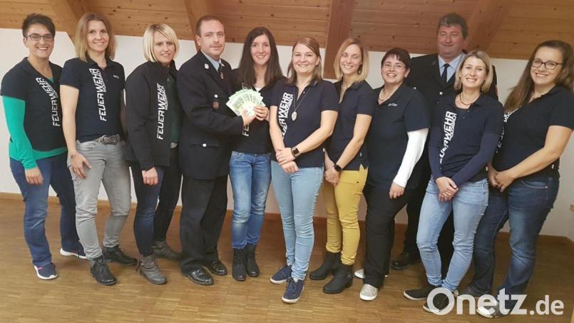 Das Team der Feuerwehrfrauen mit Monika Rappl überreicht, auch im Namen ihrer Helferinnen, den Erlös von 1000 Euro aus den Kinderbasaren vom Frühling und Herbst an den Kommandanten Markus Landgraf (vorne) und Vorsitzenden Josef Hierold jun. für die Verbesserung des Feuerlöschwesens. Bild: gi