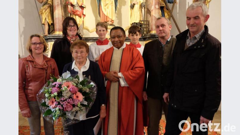 Pfarrer Cyprian Anyanwu (Mitte) überreichte Rita Süß (mit Blumenstrauß) nach 44-jährigen Mesnerdienst im Auftrag von Bischof Dr. Rudolf Voderholzer die Mesner-Ehrennadel in Gold. Anerkennung sprachen auch Kirchenpfleger Michael Zimmermann (rechts), der neue Mesner Anton Werner (links daneben) und vom Mesnerteam Martina Süß und Monika Widerspick aus (von links). Bild: ohr