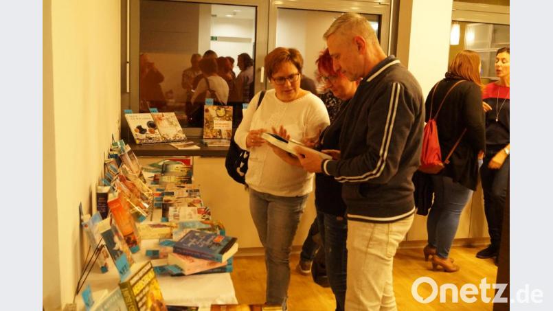 Bei lockerer Unterhaltung und in angenehmer Atmosphäre begutachten die Besucher der Mondschein-Ausleihe in der Gemeindebücherei die neuesten Romane und Jugendbücher. Bild: du