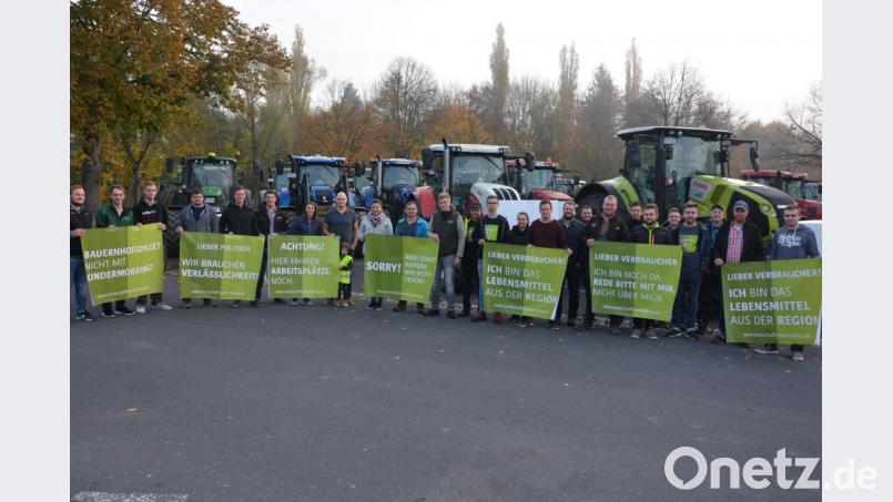 Schon in aller Früh machten sich am Dienstag rund 60 Traktorfahrer vom Tirschenreuther Großparkplatz aus auf die Fahrt zur Großkundgebung nach Bayreuth. An der Haltestelle in Kemnath reihten sich weitere Traktorfahrer in den Demonstrationszug nach Bayreuth ein. Vor der Abfahrt in Tirschenreuth stellten sich die Bauern zu einem Bild und hielten die Transparente, mit denen sie später demonstrierten. Mit im Bild Organisator Johannes Dietz (Sechster von links). Bild: jr