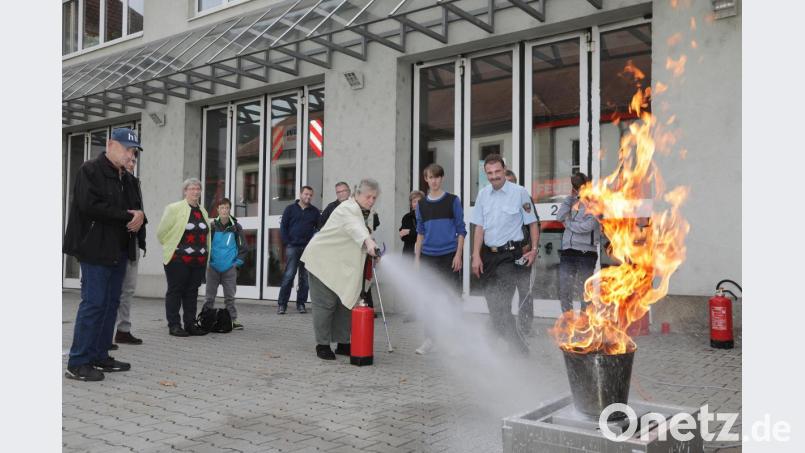 Die Rentnerin bekämpft unter Aufsicht von Stadtbrandrat Richard Schieder (rechts) erfolgreich die Flammen. Bild: Wolfgang Steinbacher