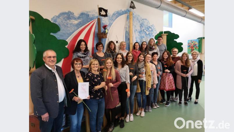 Mit Blumen bedankte sich Bürgermeister Richard Tischler (links) beim pädagogischen Personal des Kindergartens St. Martin mit Krippe und Hort unter der Leitung von Gabi Schönberger (Zweite von links). Die Dozenten Kathleen Bornfleth (rechts) und Jürgen Schindler (zweite Reihe rechts) machten das Team in einer elftägigen Fortbildung im Thema &quot;Psychomotorik&quot; fit. Bild: hir