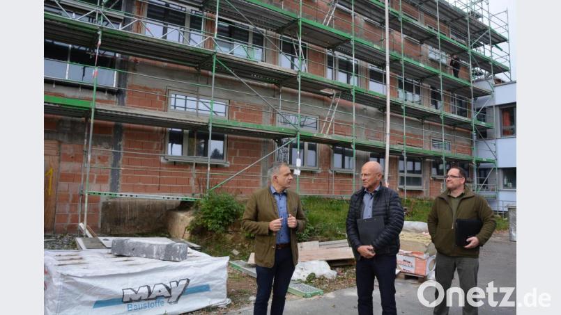 Blick auf die Außenfassade der Grundschule mit (von links) Bürgermeister Roland Grillmeier, Architekt Armin Juretzka und Bauleiter Mirko Bertl. Anfang November soll mit der Dämmung der Außenfassade begonnen werden. Bild: jr