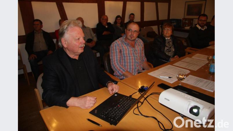 Vor den Gemeinderäten und einigen Gästen erläuterte Architekt Ernst Schöberl (links) die Ideen, wie der künftige Brunnen- beziehungsweise Denkmalstandort einmal aussehen könnte. Bild: wro