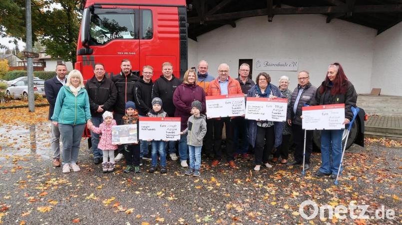 Den Fest-Erlös des zweiten Trucker-Treffens in Friedenfels spendete der Truckerverein „Bäärenbande“ mit (hinten von links) Micha Hofmann (Prokurist der Spedition Steinbach) sowie Vorsitzendem Nico Scharrer, Vereinsmitglied Patrick Backsmann, Kassier Heiko Schieder und Zweitem Vorsitzenden Torsten Schmitt an (vorne von rechts, mit Schecks) Daniela Riedl vom Tierheim Tirschenreuth, Claudia Kick (Kinderklinik Weiden), Herbert Putzer (Kinderkrebshilfe in der Region Oberpfalz Nord) sowie an Nicole Lippert (vorne Mitte) und Helga Trottmann (vorne links) vom Kinderhaus Friedenfels. Bild: bsc