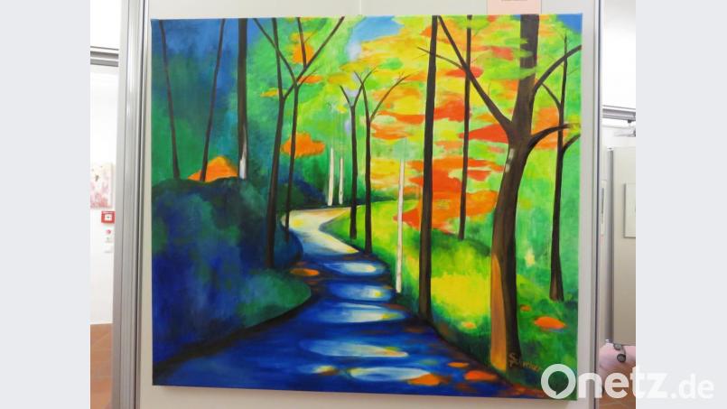 Vorsitzende Petra Schicker zeigt drei eindrucksvolle, mystiche Naturdarstellungen. Bild: ubb