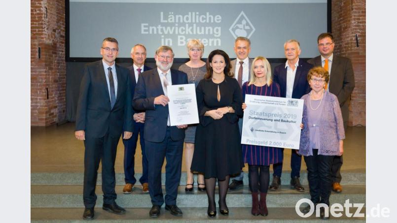 Die Marktgemeinde Mähring hat in vorbildlicher Weise das ehemalige Schul- und Rathaus saniert. Dafür überreichte Ministerin Michaela Kaniber (vorne, Mitte) an Bürgermeister Josef Schmidkonz (Dritter von links) den Staatspreis für Dorferneuerung und Baukultur. Bild: Seyfarth/StMELF/exb