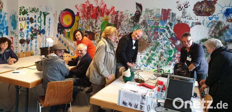 Ziad Alibrahim aus Syrien, Hans Wöhrl (sitzend), Herbert Kusche (stehend), Daniela Dittrich (mit orangem Pulli) und Arno Preißinger (stehend, schwarzer Pulli) bemühten sich nach Kräften, die defekten Geräte zu reparieren. Bild: jzk