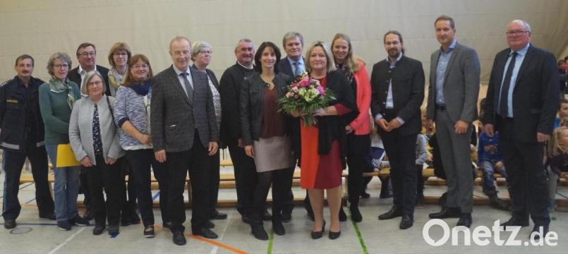Eine große Schar an Ehrengästen gaben Rektorin Christine Schneider (mit Blumenstrauß) bei ihrer Einführung die Ehre. Bürgermeister Heinz Weigl, Schulrat Jürgen Bomertl und Elternbeiratsvorsitzender Alexander Ried (von links) sowie Mittelschul-Rektor Werner Winderl (Sechster von rechts) und Dekan Alfons Kaufmann (Achter von rechts) sprachen Grußworte. Bild: weu