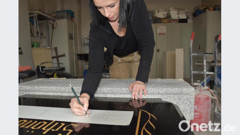 Julia Pröll mag vor allem das Künsterlische an ihrem Beruf: Hier zeichnet die Steinmetz-Meisterin aus Schwandorf freihändig Namenszüge in altdeutscher Schrift auf einen Grabstein. Bild: Tobias Gräf