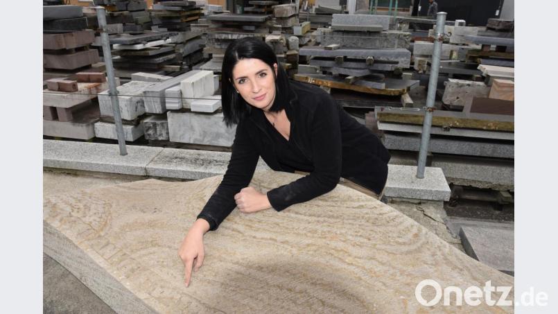 "Im Büro fühle ich mich eingesperrt. Ich liebe die Abwechslung in meinem Beruf." Julia Pröll kniend über ihrem Meisterstück. Im Hintergrund gelagerte Natursteine am Hof des Steinmetz-Betriebs Pröll in Schwandorf. Bild: Tobias Gräf