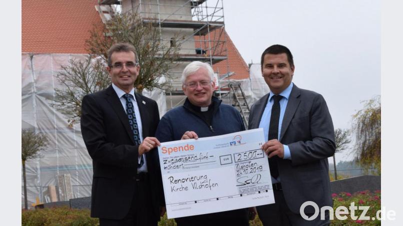 Für die Sanierung der Pfarrkirche St. Michael in Vilshofen überreichten Karl Schlagbauer (links) und Michael Doblinger (rechts) von der Raiffeisenbank Unteres Vilstal einen Scheck über 2500 Euro an Pfarrer Gottfried Schubach. Bild: bö