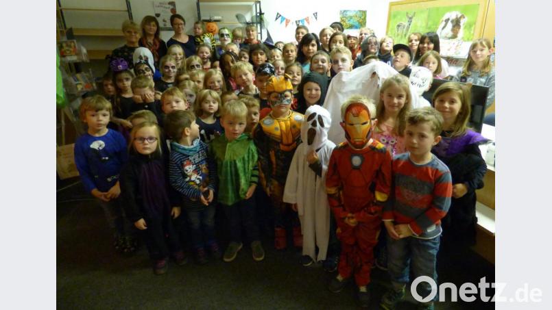 Die Bücherei bietet ein besonderes Ambiente für die Halloween-Lesung: 56 Kinder, viele davon verkleidet, lauschen den schaurig-schönen Geschichten, die Jenny Hochholzer und Carola Lindner vorlesen. Bild: mng