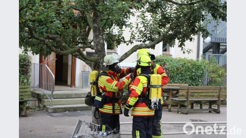Mit Atemschutzausrüstung machen sich die Helfer auf den Weg ins Gebäude, um den vermissten Schüler zu retten. Bild: ema