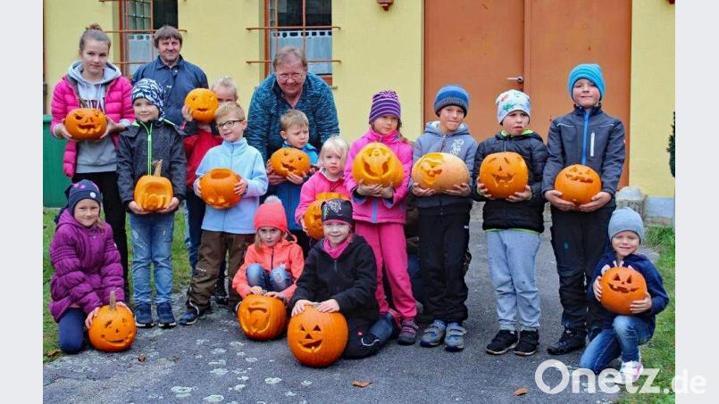 Stolz präsentierten die Kinder der ersten Gruppe mit Vorsitzender Maria Mayer ihre Kürbisköpfe – alle mit einem „so richtig grausligen Halloweeng’sicht“. Sämtliche Schnitzer waren mit großem Eifer bei der Sache und freuen sich jetzt schon auf eine gewisse Schockwirkung ihrer Kunstwerke. Bild: sön