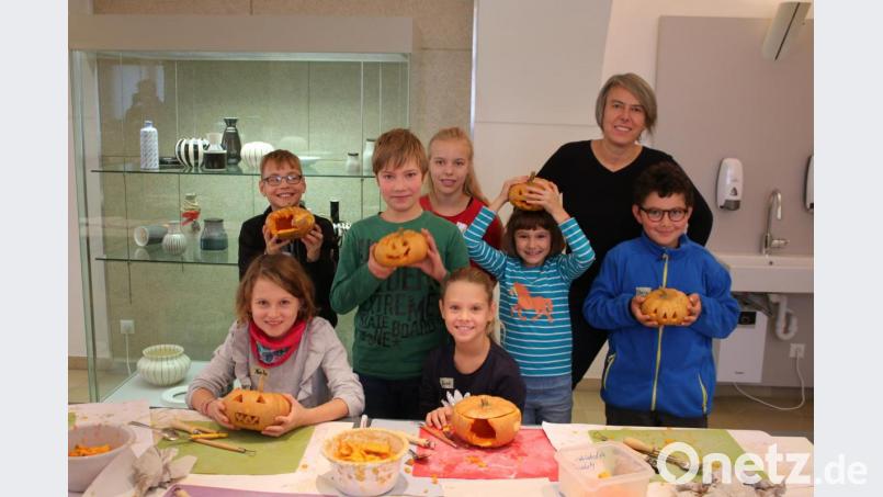 Irene Fritz zeigt den Kindern, wie sie den Kürbis bearbeiten müssen. Die Auswahl der Kinder ist äußerst kreativ. Bild: sne