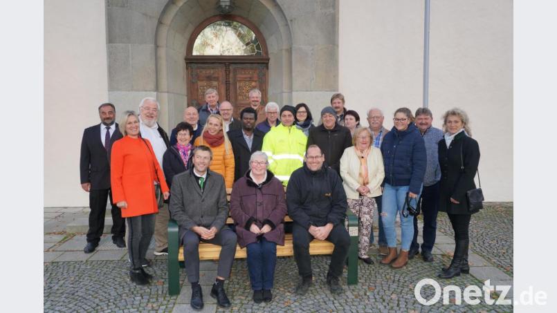 Am Waldthurner Kirchplatz, links neben der Eingangstür zur Kirche St. Sebastian, wird die erste Sitzbank platziert. Für das Pressefoto wurde die Sitzgelegenheit kurzerhand nach vorne gestellt. Bild: fvo