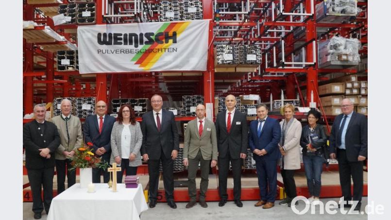 Dekan Alfons Kaufmann (links) segnete die neue Lagerhalle im Beisein von Bezirkstagspräsidenten Franz Löffler (Fünfter von links), stellvertretendem Landrat Arnold Kimmerl (Zweiter von links) und einer großen Zahl an Ehrengästen. Geschäftsführer Uwe Kratz (Dritter von links) bedankte sich fürs Kommen. Bild: weu