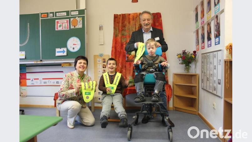 Direktorin Christa Siegler und der Vorsitzende der Kreisverkehrswacht Amberg, Gernot Schötz, überreichen die Warnwesten an Schulanfänger der Rupert-Egenberger-Schule in Amberg. Bild: AOK Amberg/exb