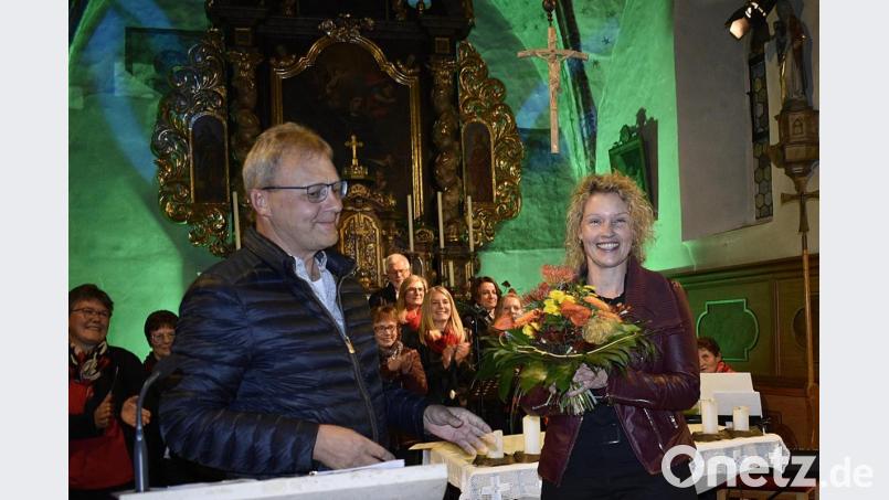 Pfarrgemeinderatsvorsitzender Albert Siegler überreicht Blumen an Chorleiterin Michaela Neukam. Bild: Karl Schwemmer
