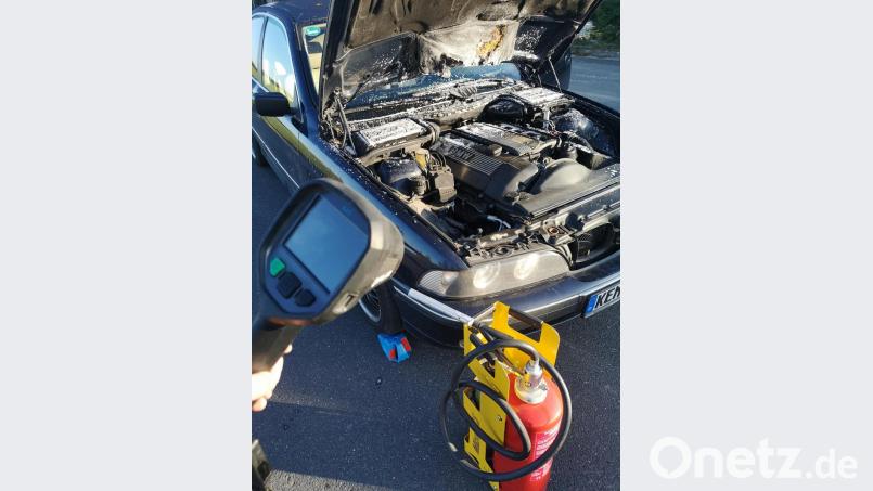 Mit einem Kleinlöschgerät (vorne rechts) wurde der Kleinbrand im Motorraum des BMW auf dem Gelände des Feuerwehrhauses abgelöscht und mit einer Wärmebildkamera (links im Bild) nachkontrolliert. Zudem wurde das Fahrzeug gegen Wegrollen gesichert. Bild: mde