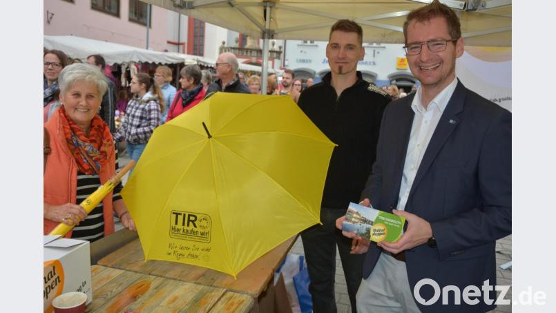 Dr. Matthias Segerer (IHK Regensburg ) und Marcus Fürst (von rechts) standen im Infostand der Tirschenreuther Inforunde und verteilten 400 gelbe Regenschirme, 1000 Papiertüten, sowie eine Menge Infomaterial zum Thema „Heimatshoppen“. Lokal einkaufen, statt global im Onlinehandel, hieß der Slogan. Bild: jr