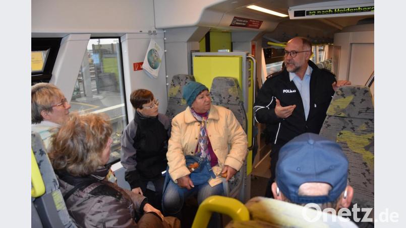 Josef Prill, Präventionsbeauftragter im Bundespolizeirevier Weiden (rechts), gibt den Sensiwen-Teilnehmern in einem Regionalzug Sicherheitstipps für Bus und Bahn. Bild: jak
