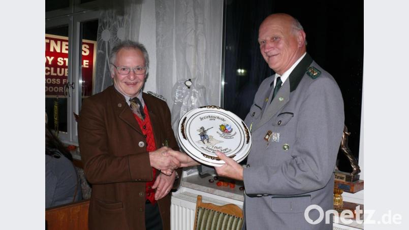 Bezirks-Schriftführer Bernhard Auburger (links) überreicht an Alfred Koch die Bezirksscheibe des 66. Bezirksschießens im April in Waldsassen. Bild: kgg