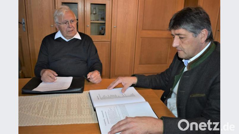 Monsignore Karl Wohlgut (links) überreicht den dritten Grafenwöhrer Almanach an Bürgermeister Edgar Knobloch. Bild: rgr