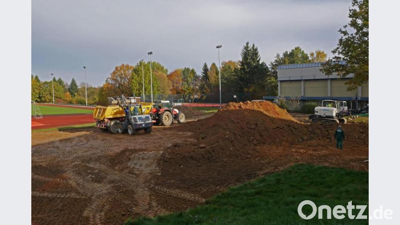 Die Erdarbeiten für den neuen Allwetterplatz haben bereits begonnen. Auf dem alten Allwetterplatz (hinten, Mitte) kommt später die neue Dreifachturnhalle. So lange wird noch die alte Halle (hinten, rechts) genutzt. Bild: tr
