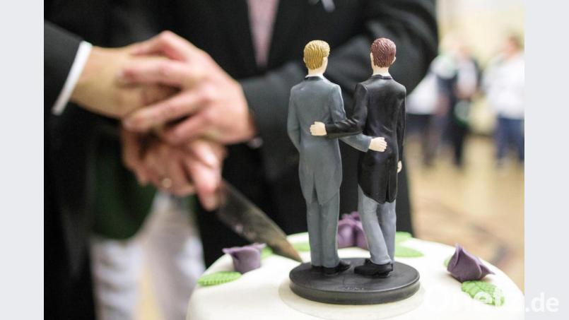 Ehe für Alle: Zwei Männer schneiden nach ihrer Eheschließung eine Hochzeitstorte an. Bild: Ina Fassbender/dpa