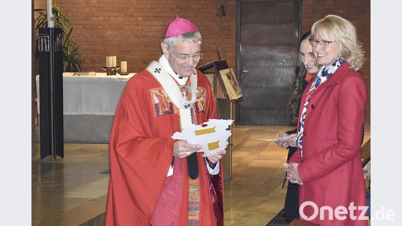 Zur Gabenbereitung übergeben Pfarrgemeinden Bilder aus ihren Pfarreien an den Erzbischof; hier Regina Schrembs (Pegnitz), daneben etwas verdeckt Sabrina Kallus (Pottenstein) Bild: sck