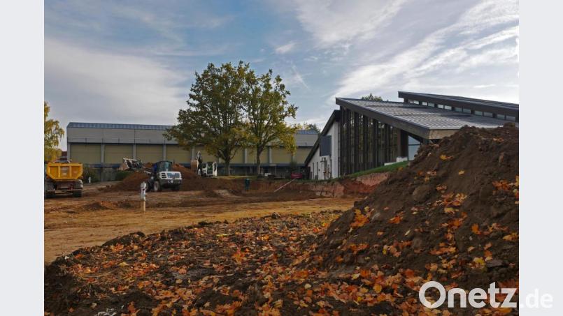 Die Erdarbeiten für den neuen Allwetterplatz haben bereits begonnen. Das Feld grenzt zukünftig an das Hallenbad (rechts) an. Im Hintergrund ist die alte Dreifachturnhalle zu sehen. Bild: tr