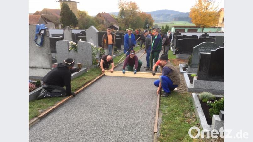 In einer Gemeinschaftsleistung brachten freiwillige Helfer den Hauptweg am Friedhof in Kulz auf Vordermann. Bild: dl