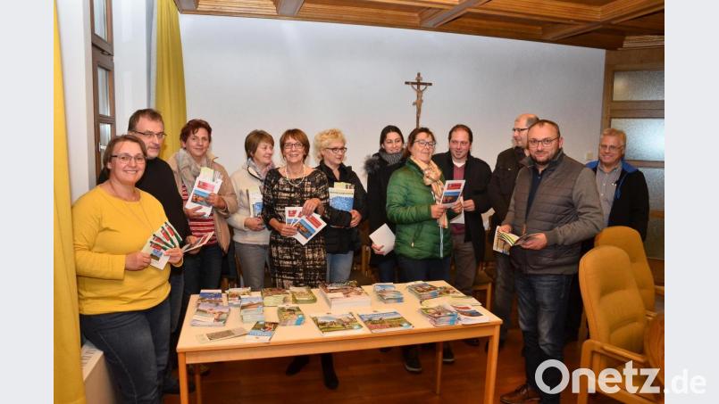 Autorin Heike Bauriedl (links) stellt den Vermietern mit Bürgermeisterin Margit Kirzinger (Fünfte von links) die neuen Broschüren der Marktgemeinde vor. Bild: fjo
