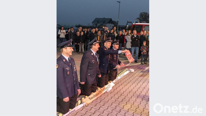 Als letzten Trumpf holt Kommandant Christian Beck einen Fotokalender mit Motiven den Traßlberger Festdamen hervor. Nun endlich erhören die Ammersrichter die Patenbitten und erlösen die Traßlberger von ihrer unbequemen Körperhaltung. Bild: chl