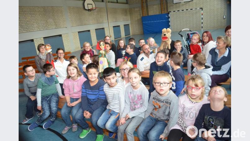 Michaela Argauer als Kasperl, Bernadette Brünnig als Hexe und Thomas Nörl als der Hund Wuschl zwischen den Kindern, die begeistert vom Puppenspiel der drei sind. Bild: fz