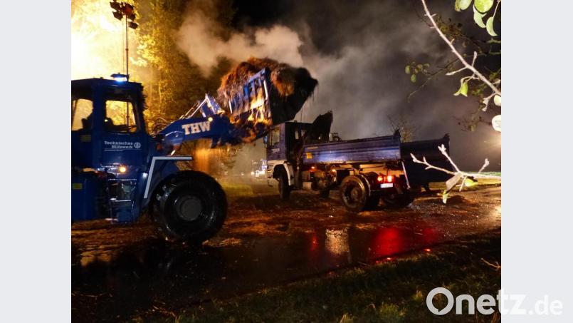 Der große Radlader des THW Weiden beim Verladen des Strohs auf einen THW Lkw des THW Schwandorf während des Brandes in Grünau. Bild: hme