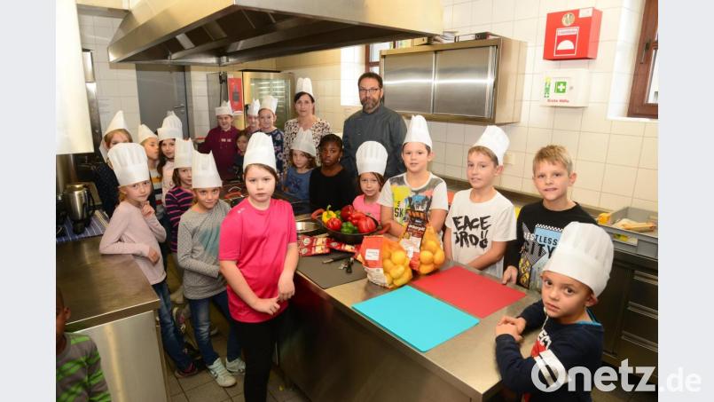 Über 20 Küchenhelfer hat Michael Schiffer beim Kinderkochkurs in der Küche des Festsaales. Bürgermeisterin Tanja Schiffmann bekommt auch eine Kochmütze. Bild: bey