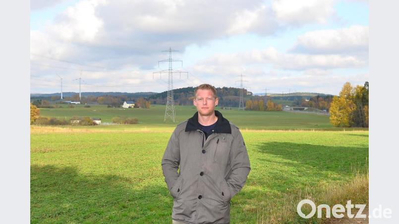 Manfred Striegl aus Lohma kümmert sich um das Projekt einer weiteren Sonnenstromanlage in unmittelbarer Nähe der 380-kv-Leitung (Mitte) aus Tschechien. Die beiden Waidhauser Windräder (links) und der Verlauf der A 6 (rechts hinten) dienen der bildlichen Orientierung. Bild: fjo