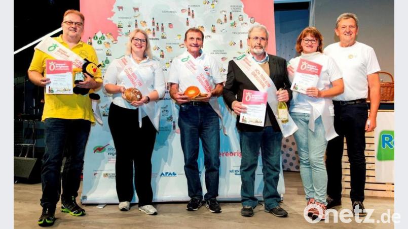 „Unsere Originale“ des Landkreises Bayreuth (von links): Waldhonig des Imkervereins Hohes Fichtelgebirge, Thermalbrot der Bäckerei Lang (Stadt Bayreuth), Küchle von Führmanns Backparadies (Stadt Bayreuth), Apfel-Holler-Sekko des Landschaftspflegeverbandes (Weidenberg), Burger von Weidenrind von der Texas Long Horn
Ranch in Prebitz sowie der Bayreuther Landrat Hermann Hübner. Bild: Rudi Ott/exb