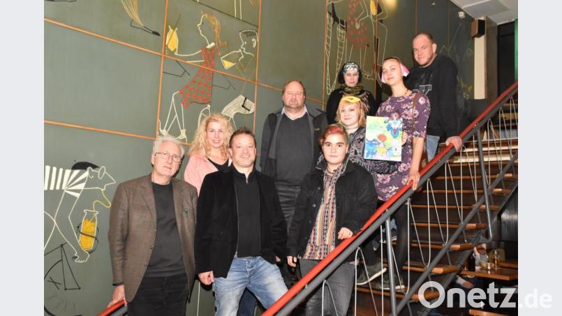 In der Milchbar stellt Kunsterzieher Wolfgang Herzer (links) die Werke des "Vereins für junge Kunst & Kultur" vor. Kuratorin Carolin Schiml (Zweite von rechts) zeigt eines ihrer Bilder. Bild: hcz