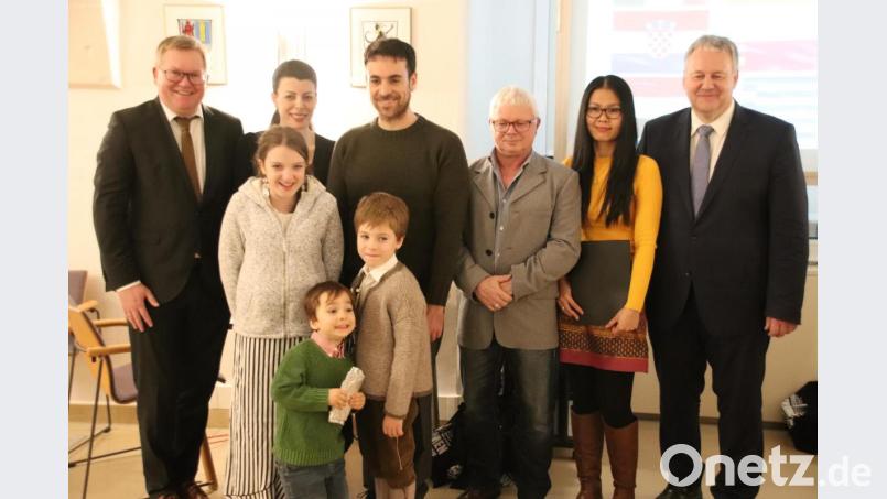 Ghevar Ismaiel (Zweiter von links), Milenko Nicolas Bugueno Gonzales (Dritter von links) und Phuangphet Schuller (Fünfte von links) wurden bei der Einbürgerungsfeier zu Deutschen und erhielten von Oberbürgermeister Michael Cerny (links) und Landrat Richard Reisinger (rechts) die Einbürgerungsurkunden. Ihre Angehörigen freuten sich mit ihnen. Bild: cog