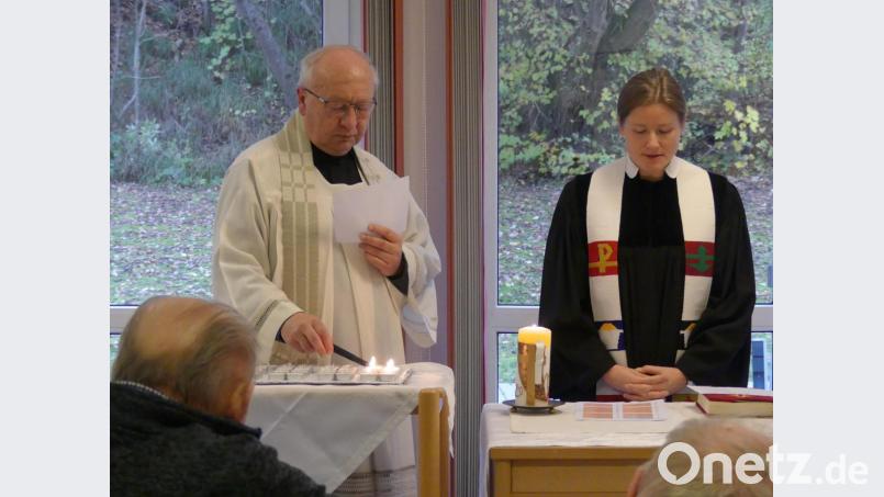 Pfarrerin Anne Utz und Ruhestandspfarrer Helmut Süß entzündeten abwechselnd Kerzen für verstorbene Heimbewohner. Bild: rn