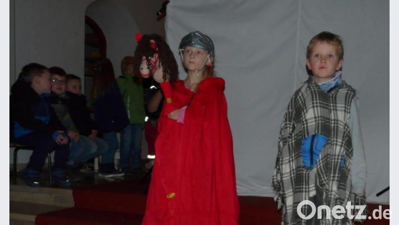 In einem Schattenspiel zeigten Louis Hess als Bettler und Maxima Reger (von rechts) als Heiliger in der Pfarrkirche die Martinslegende. Bild: mez