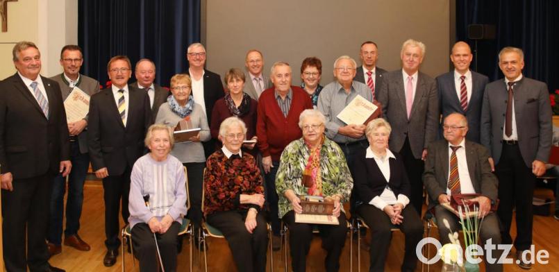 Die langjährigen Genossenschaftsmitglieder, unter ihnen Aufsichtsratsvorsitzender Willi Müller (stehend, Dritter von rechts) mit Vorstandsvorsitzendem Dieter Döppl (links), Bürgermeister Hans Donko (Dritter von links), Bezirksrätin Brigitte Scharf (stehend, Sechste von rechts), Andreas Pritschet vom Verband (Zweiter von rechts) und stellvertretender Landrat Roland Grillmeier (rechts). Bild: njn