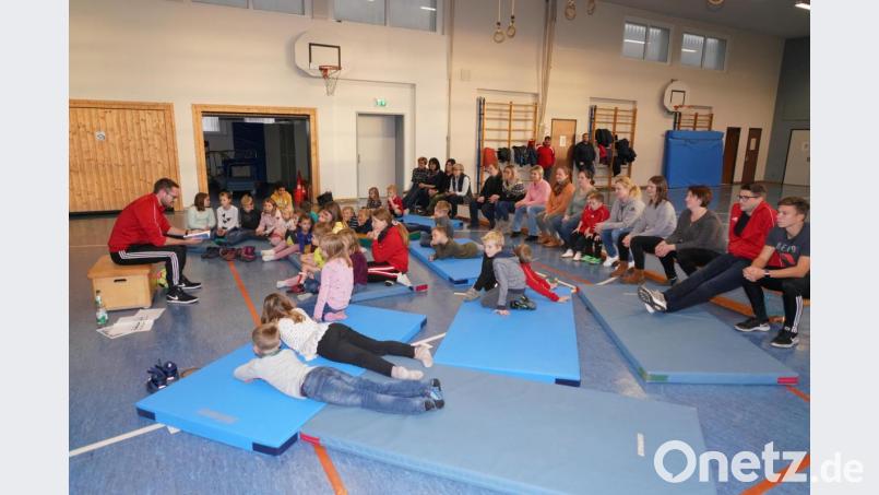 Roman Klos (links), Grundschullehrer und Fußballtrainer liest für die Kinder aus dem Jugendbuch „Wir werden Meister“. Bild: fvo